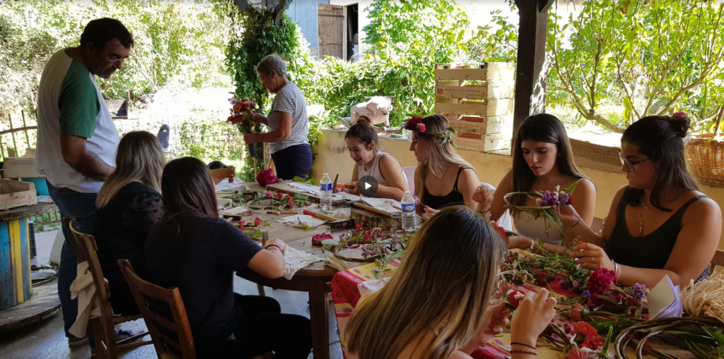 plusieurs élèves sur la table entrain de créer des couronnes de fleures